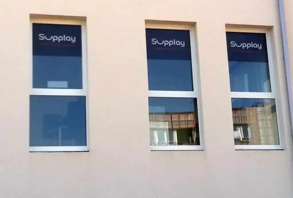 Publicité adhésive Supplay posée sur trois vitrages par l’atelier ImpriMély.